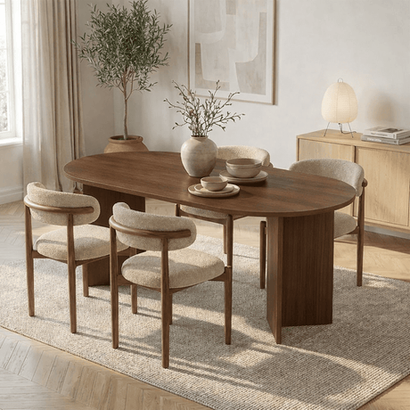 Serene eetkamer met een ovale, donkerhouten eettafel, vier bouclé stoelen en een olijfboom.